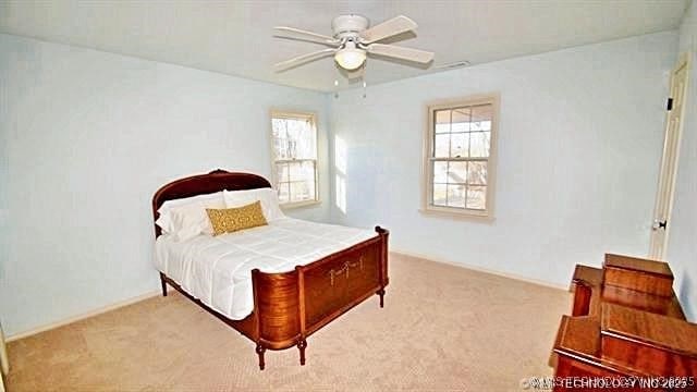 bedroom with ceiling fan and light carpet