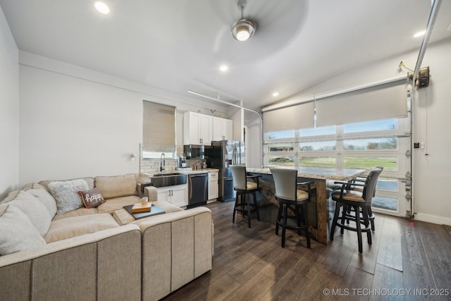 living room featuring ceiling fan, lofted ceiling, dark hardwood / wood-style floors, and sink