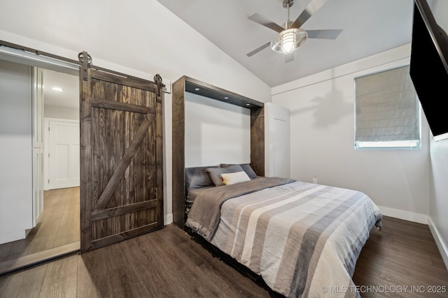 bedroom with dark wood-type flooring, ceiling fan, a barn door, and vaulted ceiling