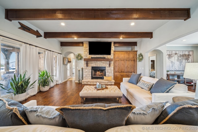 living room featuring beam ceiling, wood-type flooring, and a fireplace