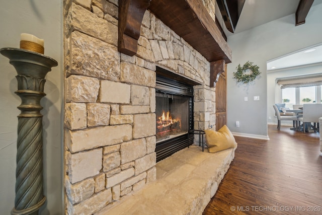 room details with hardwood / wood-style floors and a stone fireplace