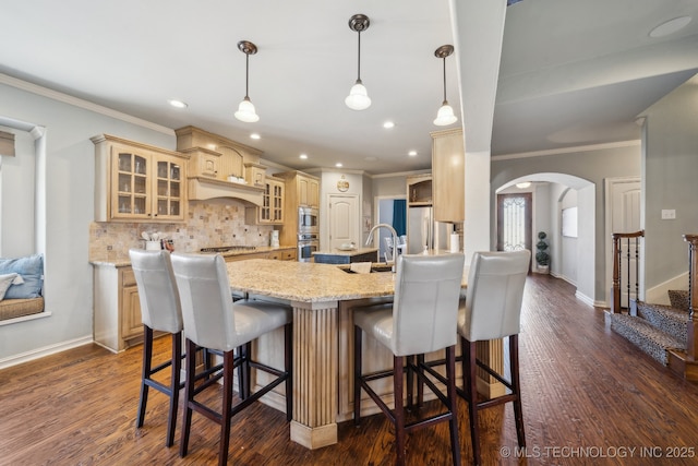 kitchen featuring dark wood-type flooring, decorative light fixtures, a kitchen breakfast bar, stainless steel appliances, and decorative backsplash