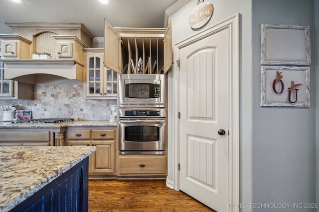 kitchen with dark wood-type flooring, light brown cabinets, stainless steel appliances, light stone countertops, and decorative backsplash