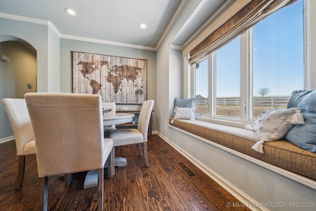 dining area with ornamental molding and dark hardwood / wood-style flooring