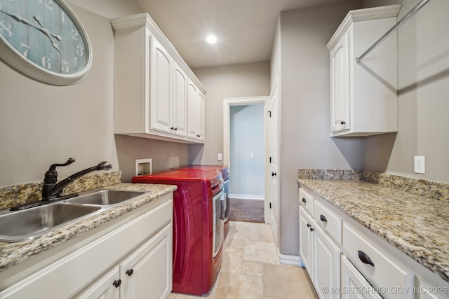 clothes washing area with cabinets, separate washer and dryer, and sink