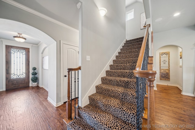 entryway featuring crown molding, plenty of natural light, and dark hardwood / wood-style floors