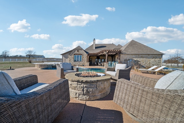 view of patio with an outdoor living space with a fire pit