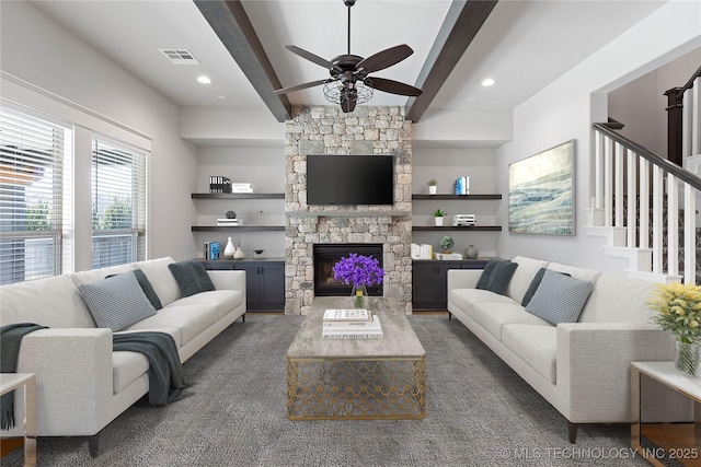 living room with ceiling fan, a fireplace, and beam ceiling