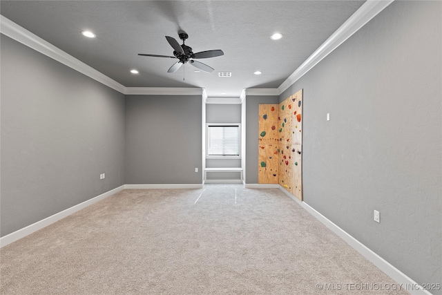 carpeted spare room with ornamental molding and ceiling fan