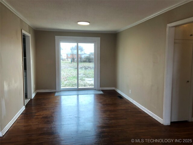 empty room with crown molding and dark wood-type flooring