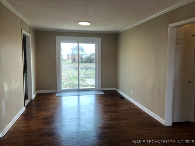 empty room with crown molding and dark wood-type flooring