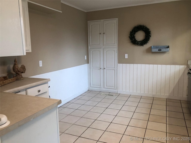 unfurnished dining area with ornamental molding and light tile patterned floors