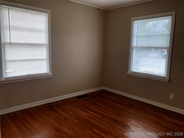 empty room with dark wood-type flooring and ornamental molding