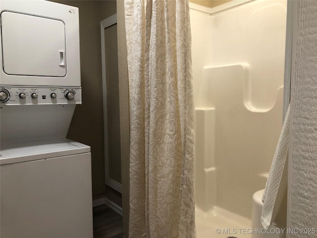 bathroom with stacked washer and dryer and a shower with shower curtain