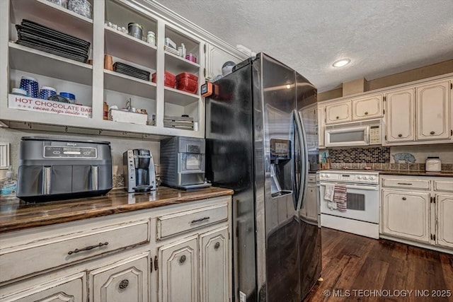 kitchen with a textured ceiling, dark hardwood / wood-style flooring, white appliances, decorative backsplash, and cream cabinetry