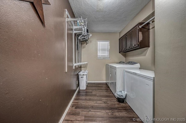 laundry area with dark wood-type flooring, cabinets, washer and dryer, and a textured ceiling