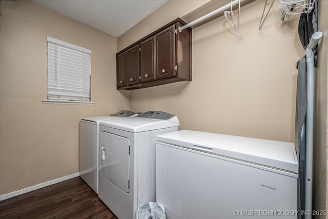 washroom featuring dark hardwood / wood-style floors, washer and clothes dryer, and cabinets