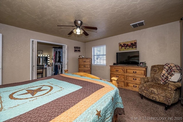 carpeted bedroom featuring ceiling fan, a closet, and a textured ceiling