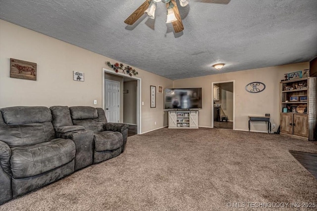 carpeted living room featuring ceiling fan and a textured ceiling