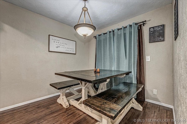 dining area featuring dark hardwood / wood-style flooring and a textured ceiling