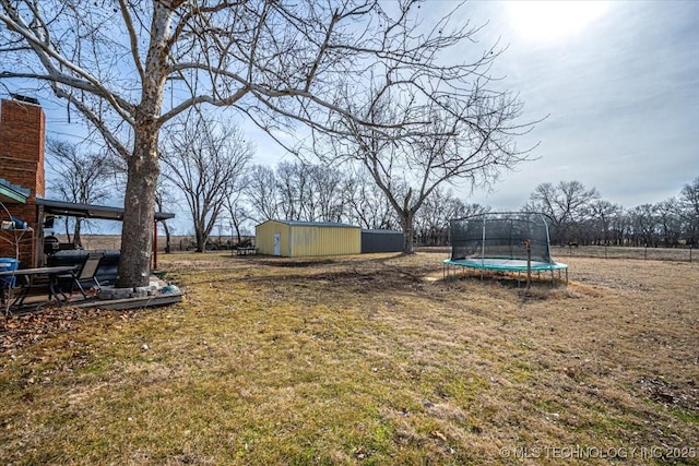 view of yard with an outbuilding and a trampoline