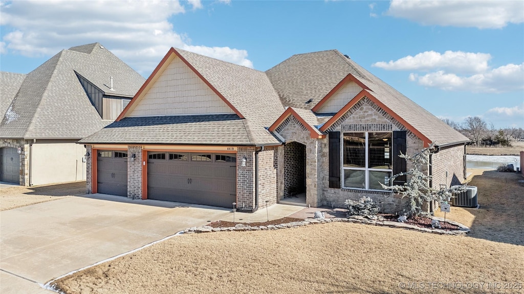 view of front of home featuring a garage and central AC