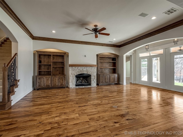 unfurnished living room with hardwood / wood-style flooring, a fireplace, built in features, and ceiling fan