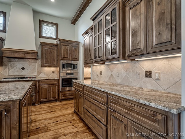 kitchen with premium range hood, stainless steel appliances, and dark brown cabinets