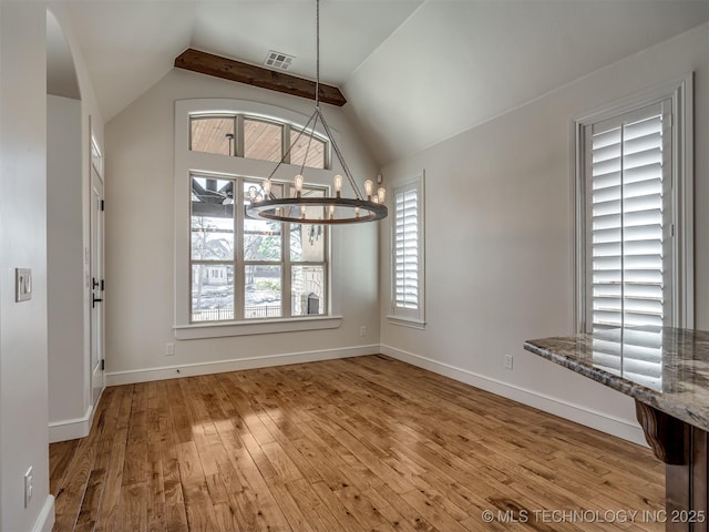 unfurnished dining area featuring wood-type flooring, vaulted ceiling with beams, and a notable chandelier