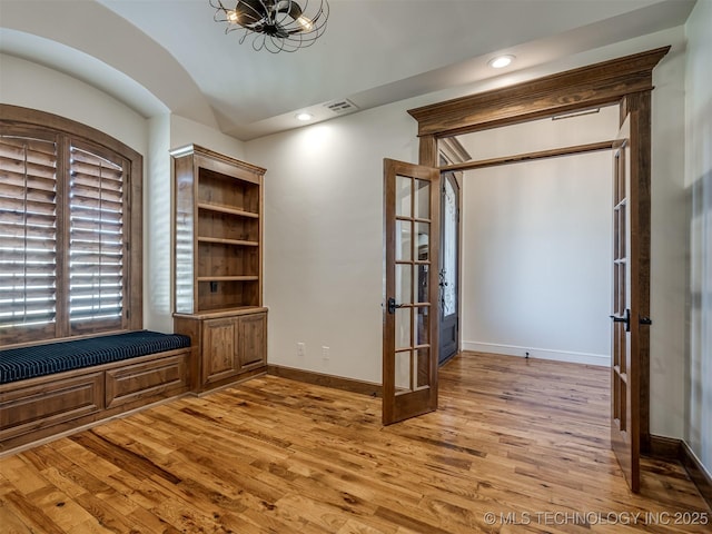 interior space featuring vaulted ceiling, light hardwood / wood-style floors, and french doors