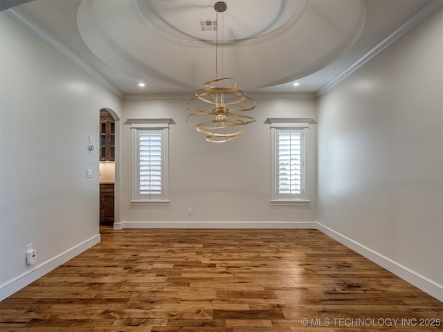 spare room with crown molding, a notable chandelier, and hardwood / wood-style flooring