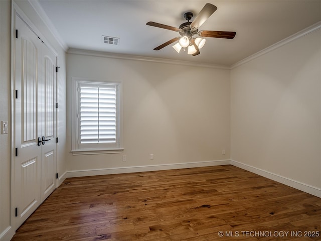 spare room with ornamental molding, ceiling fan, and dark hardwood / wood-style flooring