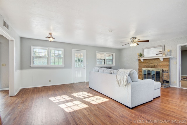 unfurnished living room with ceiling fan, a fireplace, and hardwood / wood-style floors