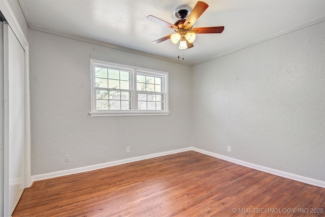 unfurnished bedroom featuring crown molding, wood-type flooring, a closet, and ceiling fan