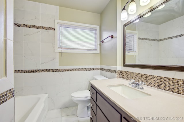 bathroom with vanity, toilet, and tile walls