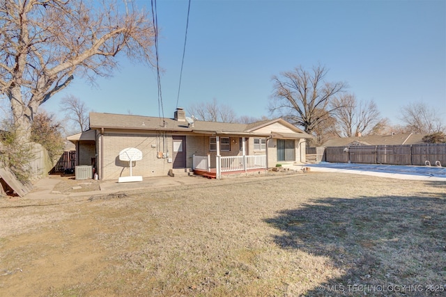 rear view of house with central AC, a yard, and covered porch