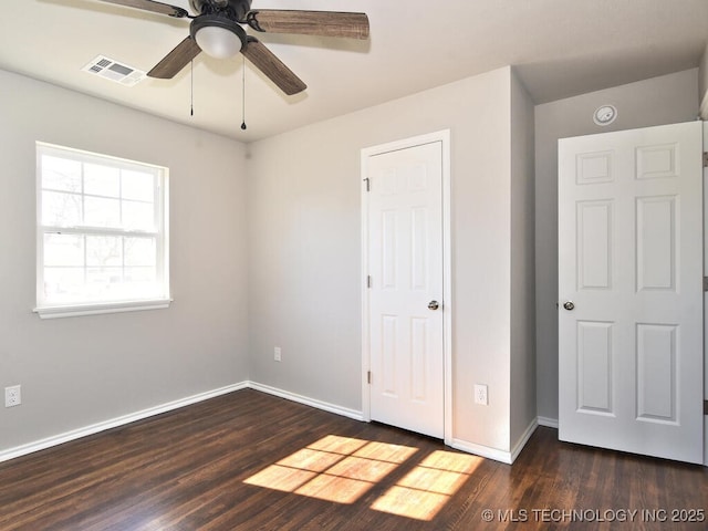 unfurnished bedroom with ceiling fan and dark hardwood / wood-style flooring