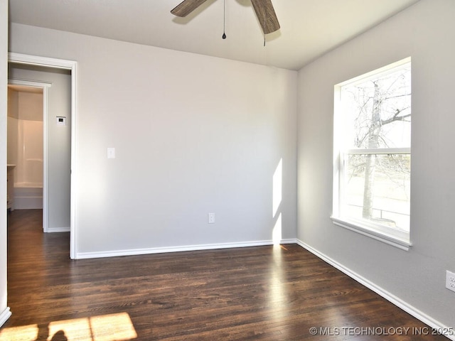 spare room with dark hardwood / wood-style floors and ceiling fan