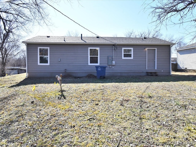 rear view of property featuring a lawn