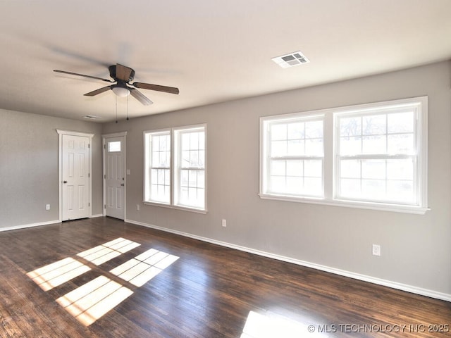 spare room featuring dark wood-type flooring and ceiling fan