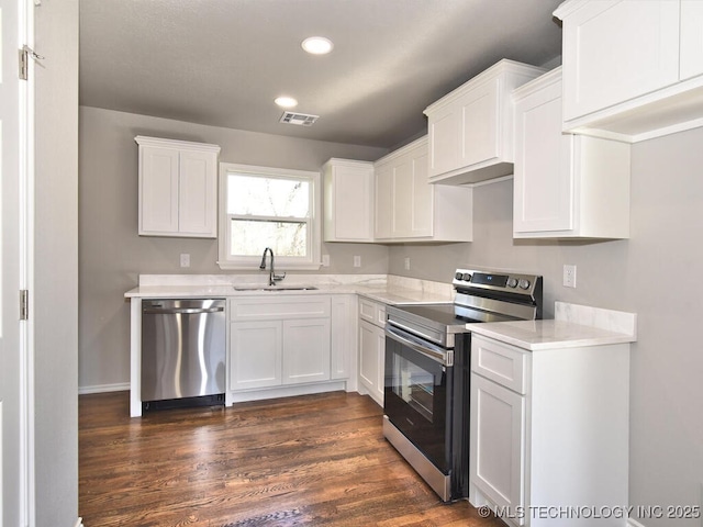 kitchen featuring sink, dark hardwood / wood-style floors, white cabinets, and appliances with stainless steel finishes