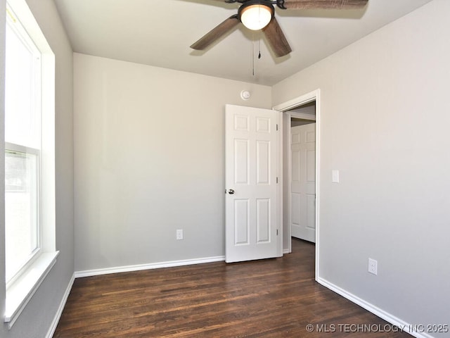 unfurnished room with dark wood-type flooring and ceiling fan