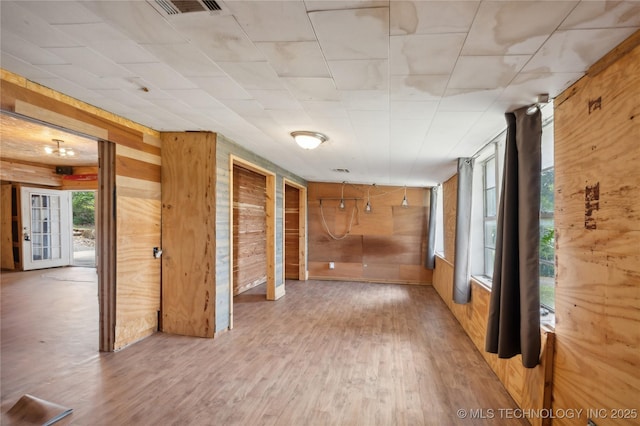 empty room featuring hardwood / wood-style flooring and wooden walls