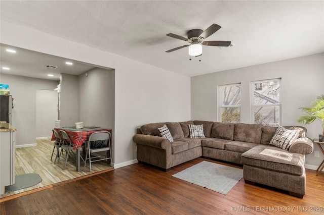 living room featuring a ceiling fan, visible vents, wood finished floors, baseboards, and recessed lighting