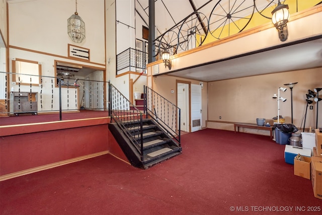 stairway with a high ceiling and carpet