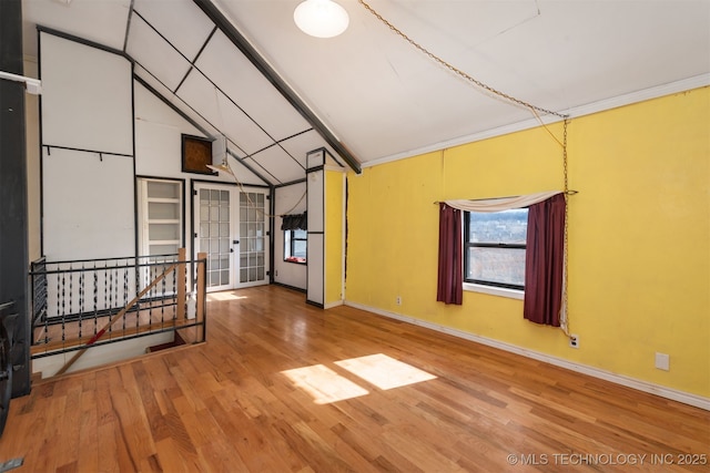 spare room with crown molding, hardwood / wood-style flooring, vaulted ceiling with beams, and french doors