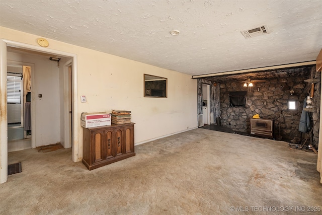 unfurnished living room with ceiling fan, light colored carpet, and a textured ceiling