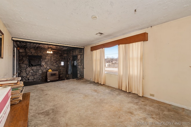 unfurnished living room featuring a textured ceiling and carpet floors