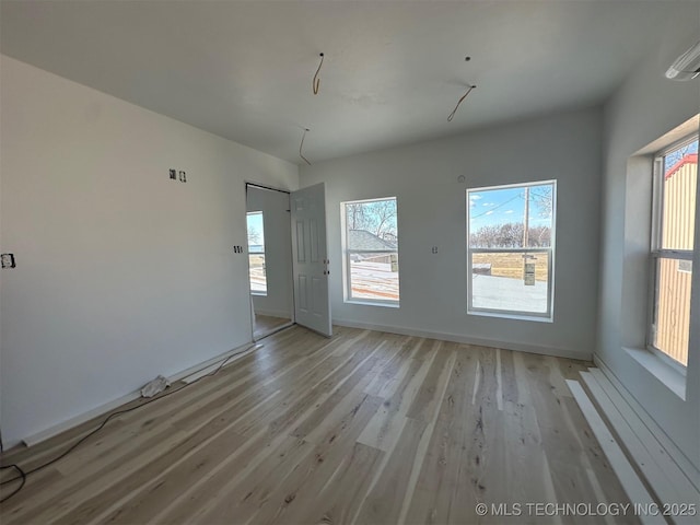 unfurnished room featuring a wealth of natural light and light wood-type flooring