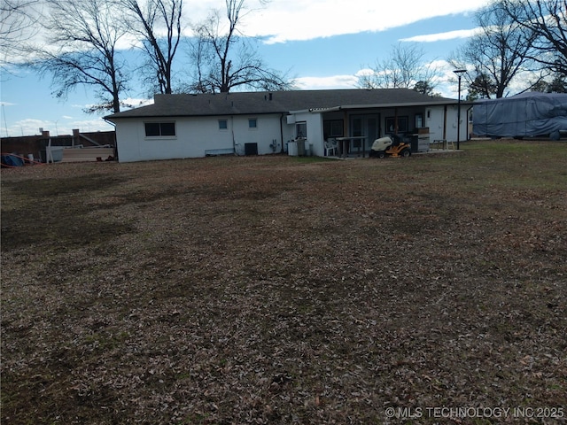 back of property featuring cooling unit and a lawn